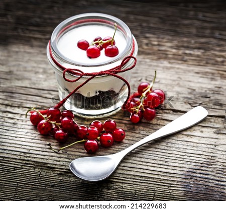 Berry dessert yogurt/ Layered dessert with berry and cream cheese in glass jar, selective focus