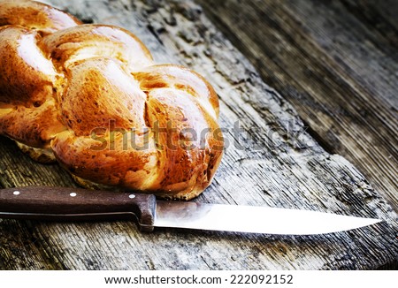 Fresh baked rustic bread loaves in paper bags on dark wood background