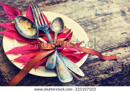 Thanksgiving table setting/ cutlery on the autumn background with autumn leaves,ribbon on wooden background/ Thanksgiving holidays background concept