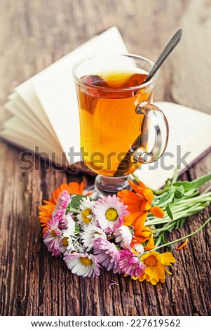 romantic autumn vintage background with books and tea/ cup of herbal tea on wooden background