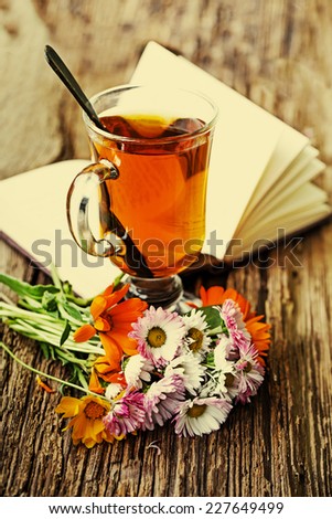romantic autumn vintage background with books and tea/ cup of herbal tea on wooden background