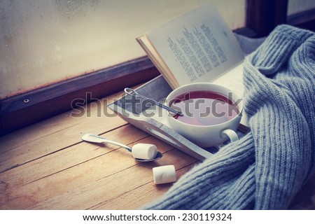 Warm knitted sweater,cup of hot tea and  book on a wooden tray