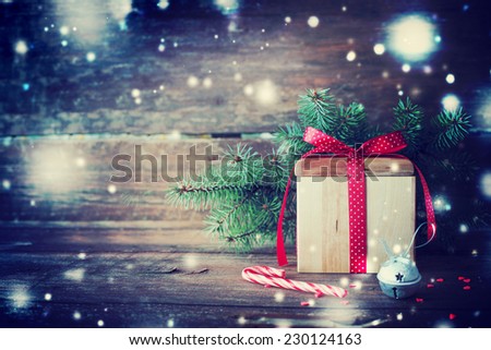 Christmas present with candy canes on dark wooden background in vintage style