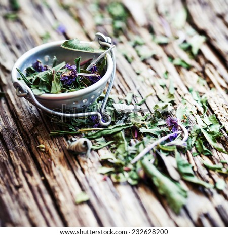 Herbal tea with wild flowers and berry on wooden background - bio food, health and diet concept