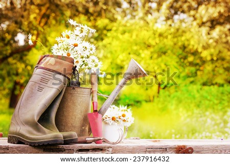 Outdoor gardening tools and flowers/ Spring Gardening tools and a straw hat on btautiful garden background