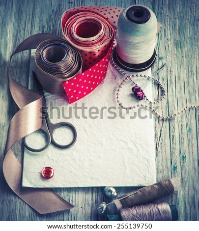 Scrapbooking craft materials/ Background with sewing tools and colored tape/Sewing kit. Scissors, bobbins with thread and needles on the old wooden background