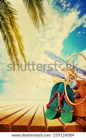 Summer accessories, swimsuit, sun glasses, bag and flip-flops. Closeup of summer beach bag