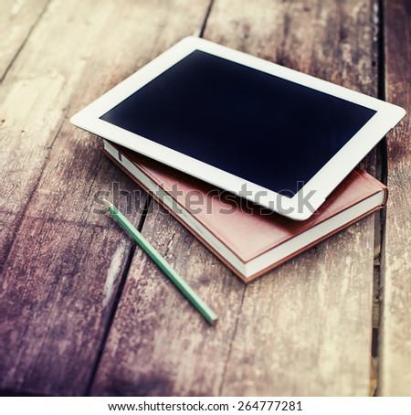 blank tablet device over a wooden workspace table/ selective focus