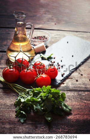 Ingredients for cooking and empty cutting board on an old wooden table. Food background with copyspace