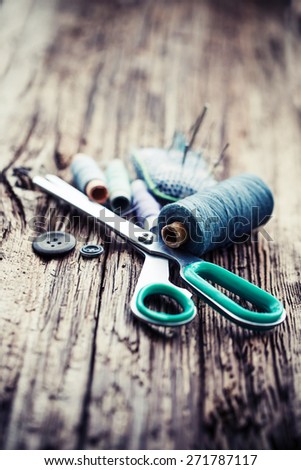 Tools for sewing and handmade: thread, scissors, pins on brown paper./selective focus
