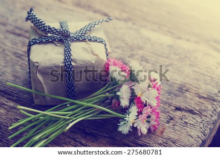 Flowers and present gift on wooden background/ Holiday background