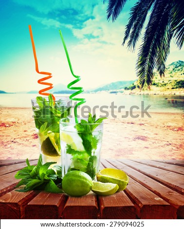 Mojito cocktail and beach in the background/ summer holiday background with two mojito cocktail