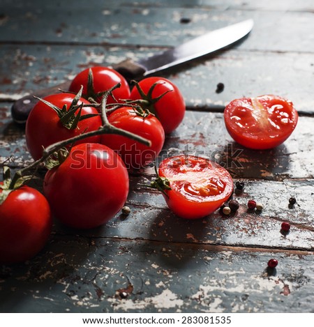 Fresh grape tomatoes with pepper for use as cooking ingredients on wooden background