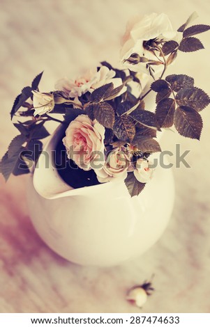 White roses on wooden desk/ Vintage flower background