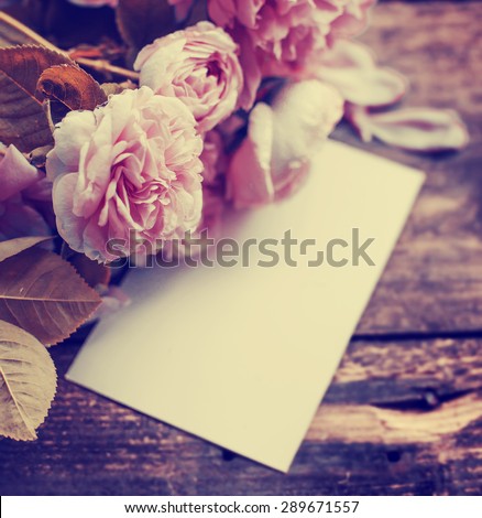 Beautiful peonies with card on wooden background/ holidays romantic background