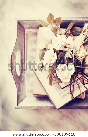 Beautiful roses with books on wooden background/ Vintage romantic background