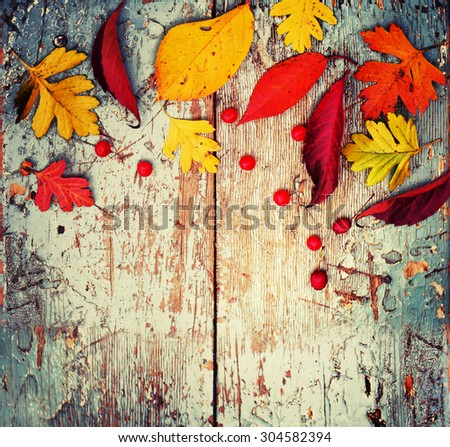 Autumn background/ Autumn leaves and berry as a heart over wooden background/Thanksgiving day concept