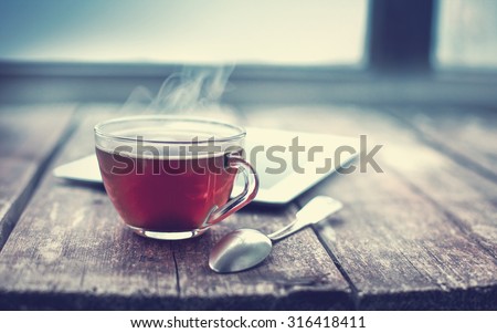 Hot tea cup on a frosty winter day window background
