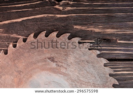 Old circular saw blade on wooden background