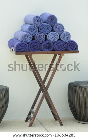 Blue towels stacked on the table, towel rolls, basket.