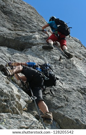 Two klettersteig climbers at steep wall
