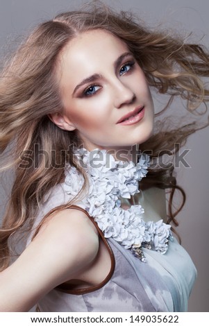 Portrait of beautiful girl with flying hair in dress with shell collar