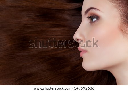 Profile portrait of beautiful girl over her long brown hair