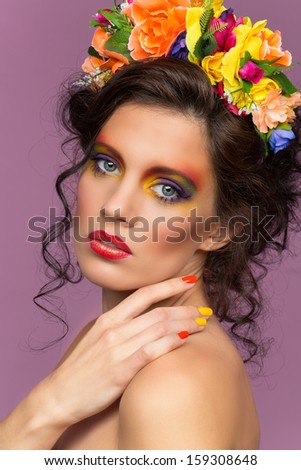 Portrait of young beautiful brunette girl wearing flower headband over purple background