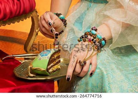 Closeup of oriental girl tasting wedding cake