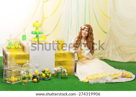 Beautiful young bride in yellow dress siiting near party table with flowers and wedding cake