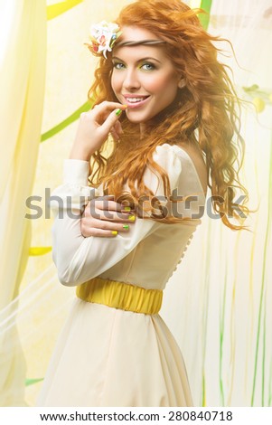 Portrait of beautiful young woman with red long hair and flower dcoration on head.