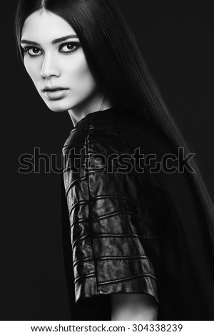 Beautiful young fashionable woman with long silky hair wearing leather top