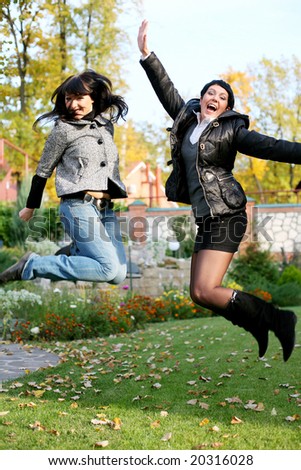 Two friends laughing, crying jumping in the garden