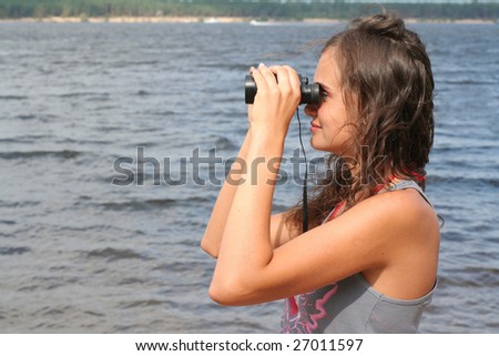 A young woman looking through binoculars