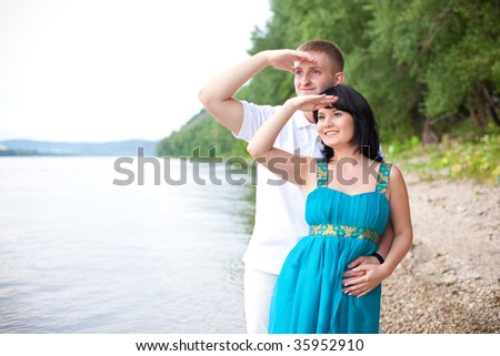 Couple is standing on the bank of the river and looking at the future