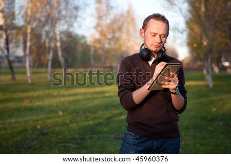 Handsome man with headphones writing in his notebook