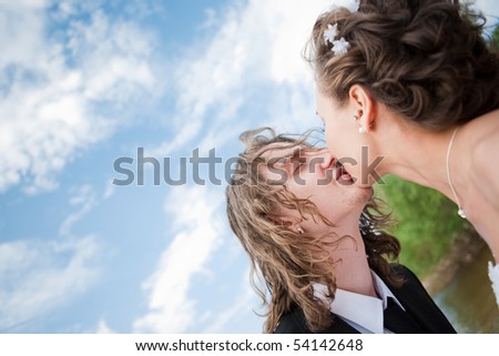 Wedding kiss over sky background