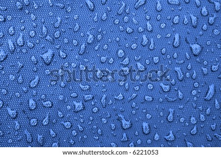 Water drops pattern over a waterproof cloth, blue background