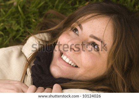 Portrait of a naturally beautiful wondering girl in a green meadow in the early spring