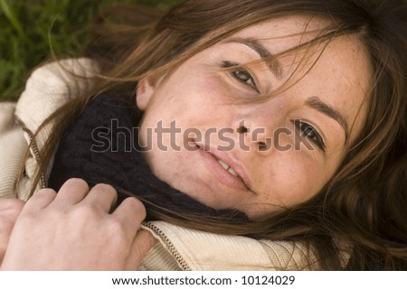 Portrait of a naturally beautiful cheerful girl in a green meadow in the early spring