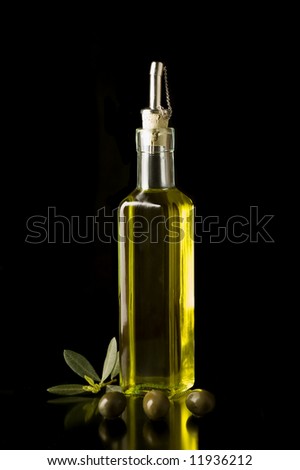 Bottle of fine Italian extra virgin olive oil with olives and some leaves Bottle of fine Italian extra virgin olive oil with olives and some leaves