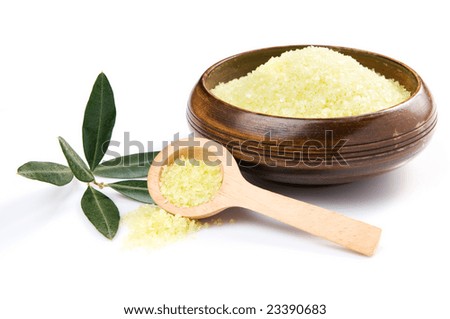Olive bath salt in a bowl with wooden spoon and branch isolated on white background