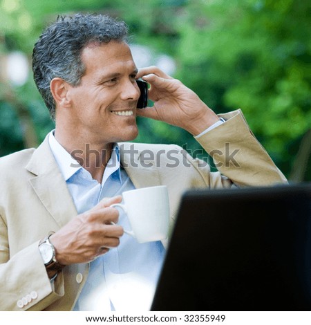 stock photo Healthy mature businessman working outdoor with mobile and 