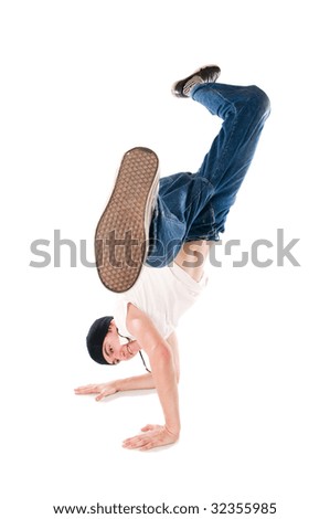 Young happy breakdancer standing upside down on hands with a flying kick