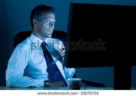 Mature businessman working late at night in his office
