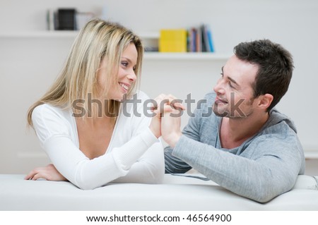 Young couple taking hands each other with love in their living room