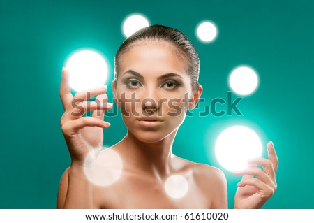 Beautiful fairy female model holding spheres of light on her hands, professional beauty makeup