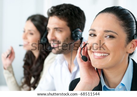 Beautiful young lady talking on headset at call center office