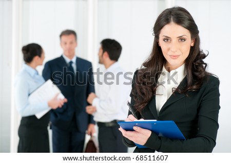 Satisfied smiling business woman compiling a form for a job recruitment or interview at office