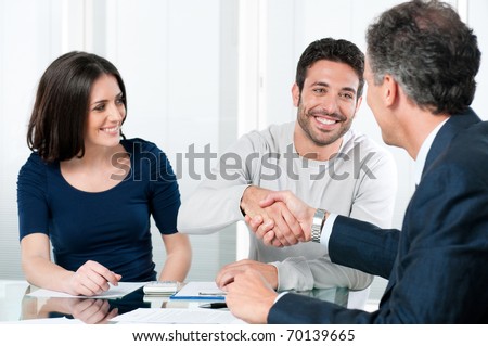 Happy couple seal a deal with their personal financial advisor at home